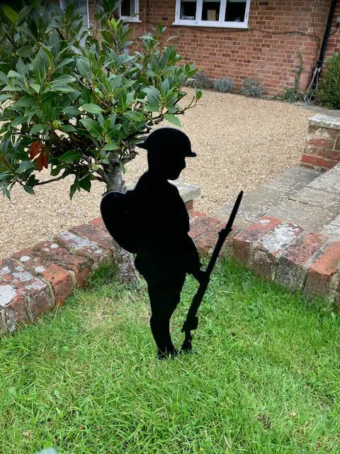 Black metal silhouette of soldier with backpack, gun and helmet solemnly looking down in respect of their fallen comrades. Made from strong 2mm thick metal and finished in a rust proof silk paint.