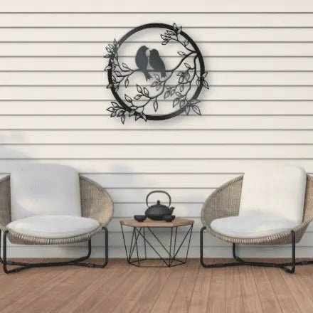 Metal Wall Art two birds siting on a branch looking at each other in a lovinq way with branches and leaves in a circular frame