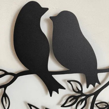 Metal Wall Art two birds siting on a branch looking at each other in a lovinq way with branches and leaves in a circular frame