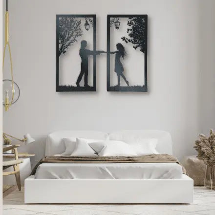 Metal wall art of boy and girl standing under a tree and lamp arms stretched out holding hands