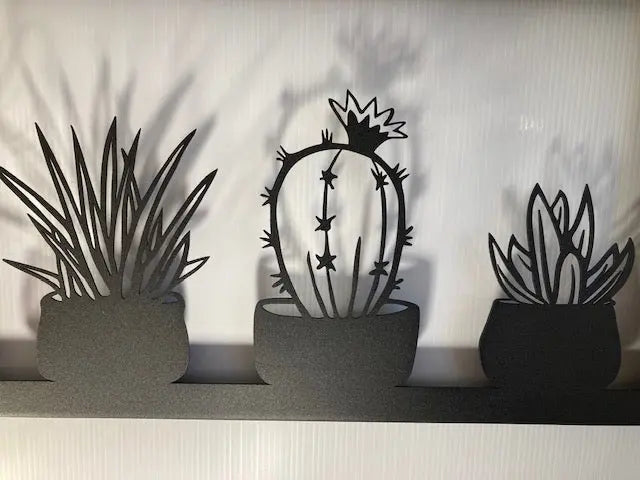 Metal wall decor showing five types of cacti in a frame, cut with great detail and gives a 3D effect on the wall behind, makes a great gift